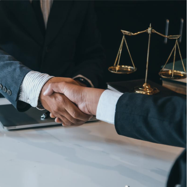 An image of a lawyer exchanging hand shake with his client